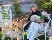 Barbara Norfleet '47, H'14 holding flowers and a dog.